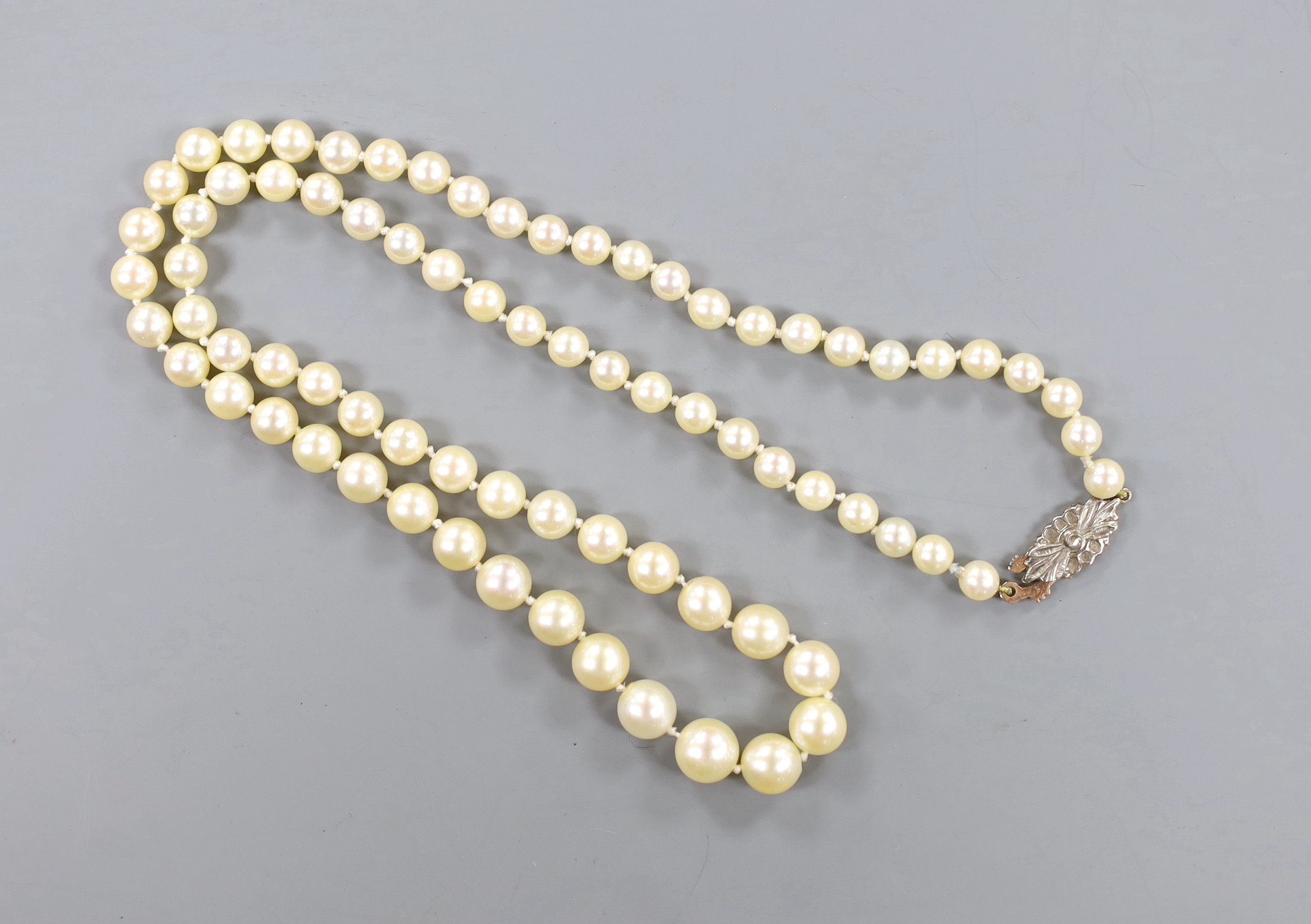 A single strand graduated cultured pearl necklace, with rose cut diamond set yellow metal clasp, 52cm.